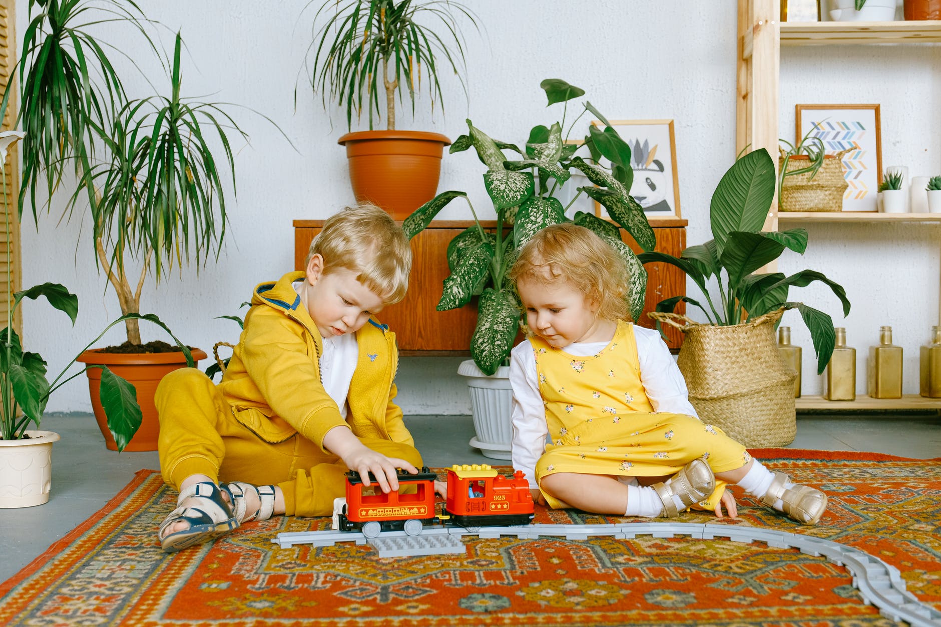 adorable little boy and girl playing with toy train