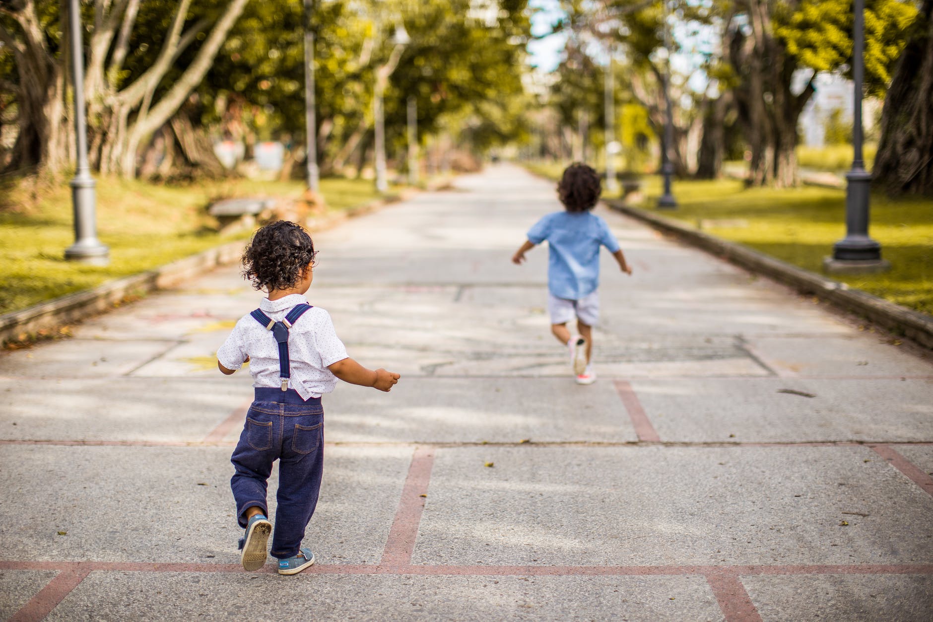 two children running on road