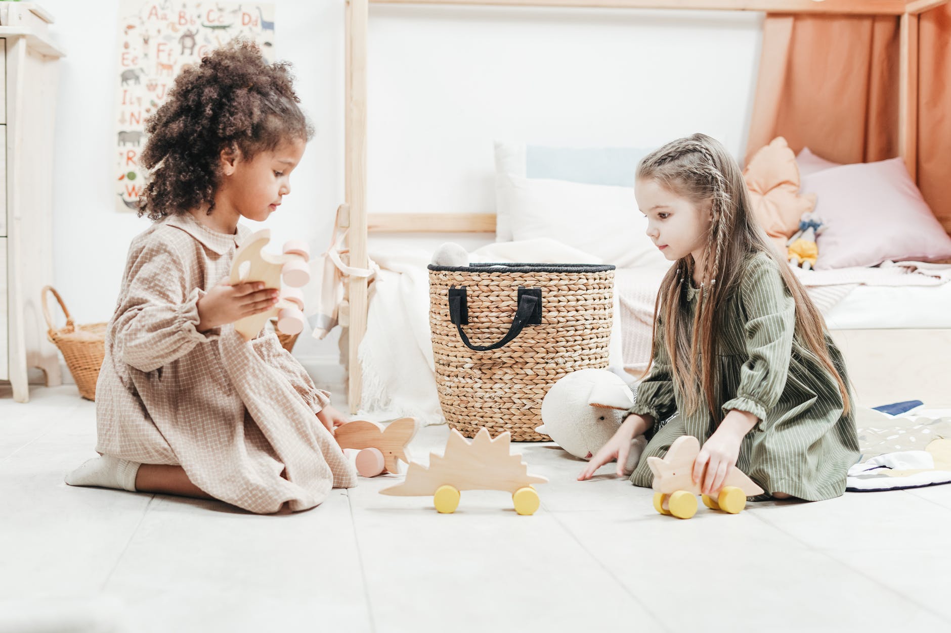 photo of two girls playing with wooden toys